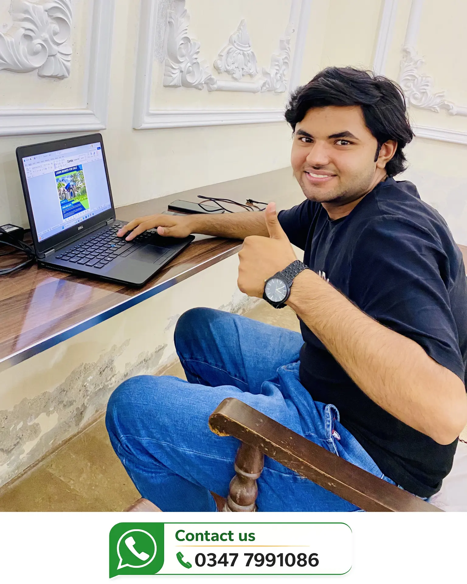 Smiling student giving a thumbs up while working on his laptop