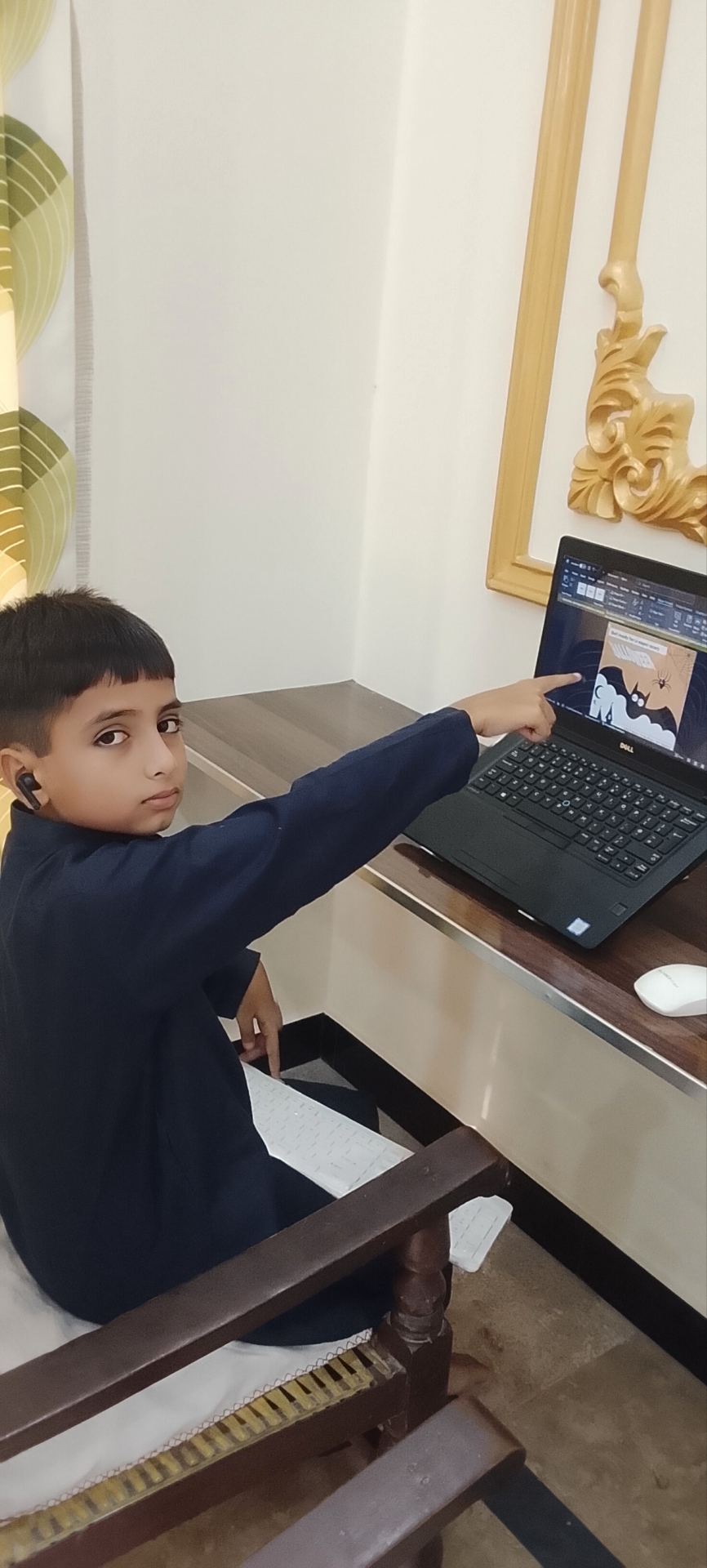 Young student pointing at his laptop screen during a practical lesson