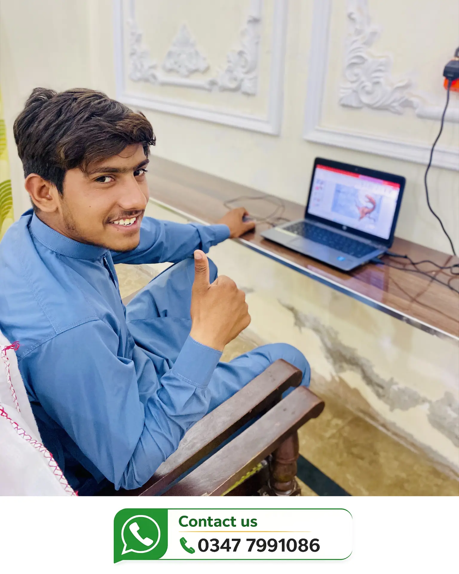 Happy student showing a thumbs up at his workstation